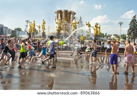 MOSCOW, RUSSIA - JULY 3: young people shooting and throwing water at each other during Water Wars flash-mob, Fountain friendship of people VDNKH, July 3, 2011, Moscow, Russia