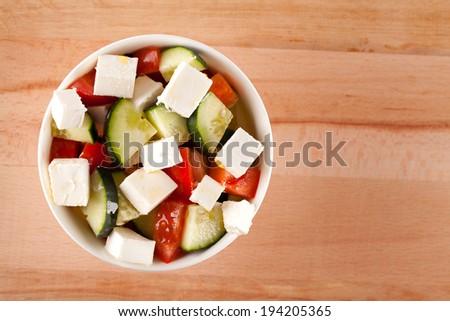 Top view of full salad in bowl on wooden table