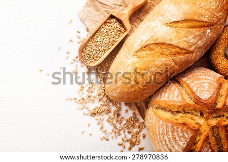 Assortment of baked bread on white wooden table background