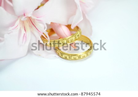 stock photo Wedding rings with pink flower on blue background