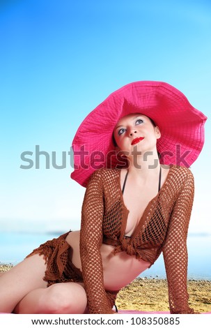 cute girl in a big red hat day summer sea