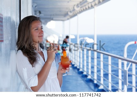 cute girl with a cocktail on a journey to the sea