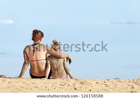 Mother and daughter in a bikini in the mud body treatment