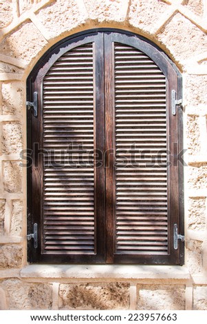 old window with brown shutters closed closeup