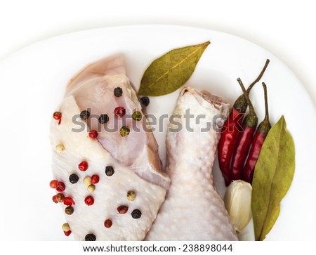 chicken legs on the plate with spices, white background