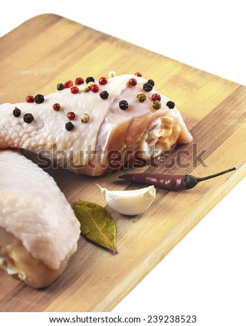 chicken feet on wooden board with spices, white background
