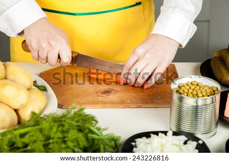 cook woman cuts a knife carrot salad