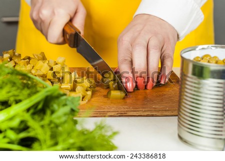 cook woman closeup sliced pickled cucumber cubes