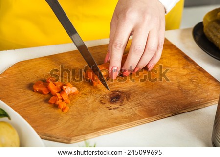 chef woman cuts a knife boiled carrot closeup