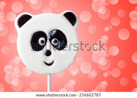 lollipop in the form of an panda on a pink background