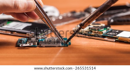 employee repairing fractured phone on a wooden background