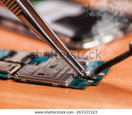 repair a broken mobile phone closeup on wooden background