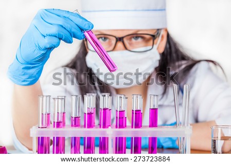laboratorian inspects the contents of the test tubes closeup on a light background