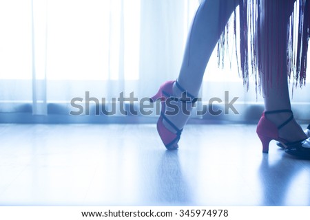 Dancing shoes feet and legs of female ballroom and latin salsa dancer dance teacher in dance school rehearsal room class.