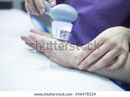 Electro stimulation used to treat pain, muscles injuries, strains and tension in hospital physiotherapy medical rehabilitation clinic for patient hand.
