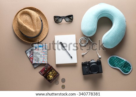 Packed suitcase of vacation items on wooden table, top view. Eye mask with the inscription \