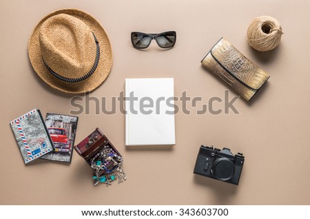 Packed suitcase of vacation items on wooden table, top view