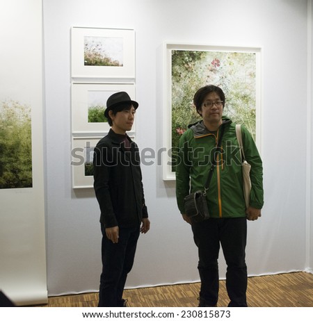 Photographer kiiro in front of his pictures at Fotofever 2014, Paris, France