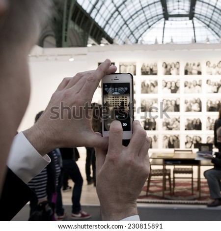 People taking a photo of a photo of Nicholas Nixon at Paris Photo art fair 2014, Paris, France