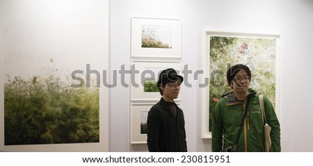 Photographer kiiro in front of his pictures at Fotofever 2014, Paris, France