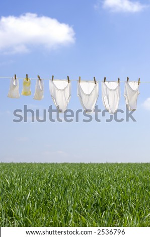 Clothes drying in the summer breeze on clear blue sky with soft clouds