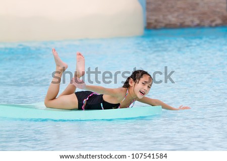Funny little girl swims in a pool