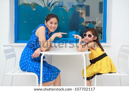 Portrait of a beautiful young woman and her daughter pointing to