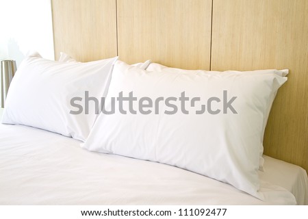 Clean white pillows and sheet on bed