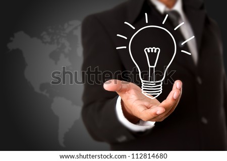 Light bulb in business hand with world map background