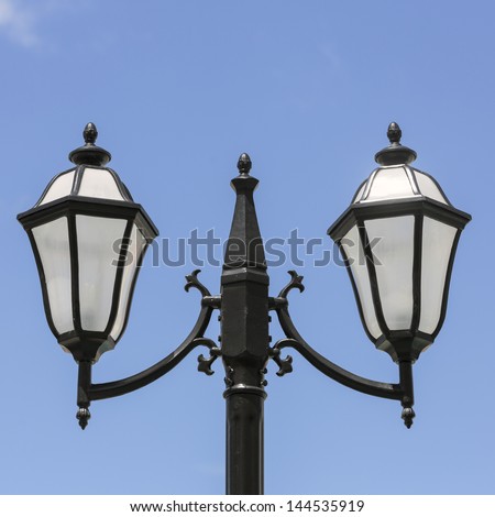 Victorian lamp post standing on blue sky