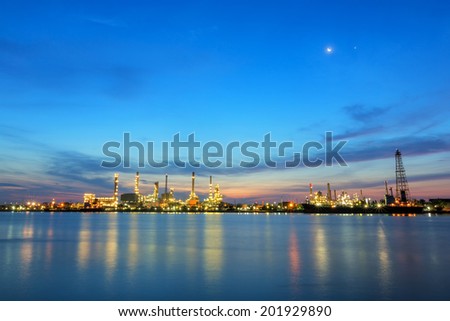 Oil refinery at twilight with the moon