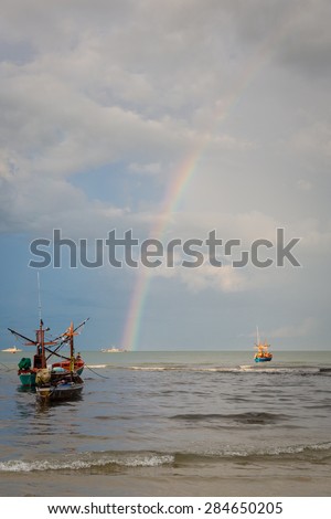 boat by the huahin beachside during beautiful sky with rainbow