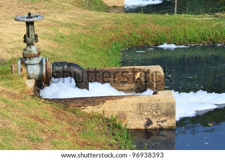 some green sewage pipes bridging a river