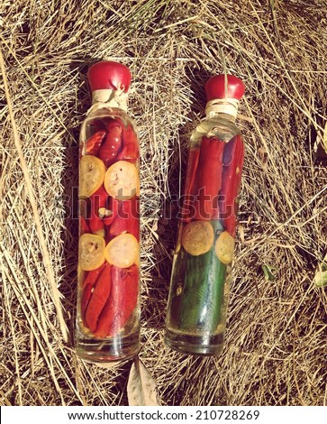 Bottles with sauced vegetables are laying in hay in tender toning