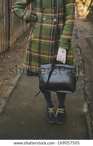 Girl and Autumn - A girl in green coat and boots holding a school bag