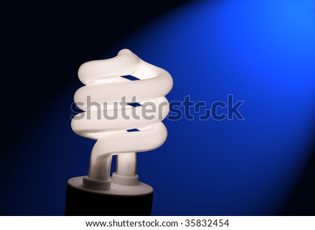 Close up photo of a compact fluorescent light bulb against a black background with a blue light streak.