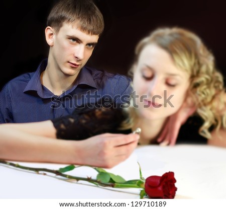 Young attractive man looking with love at girl he has made proposal