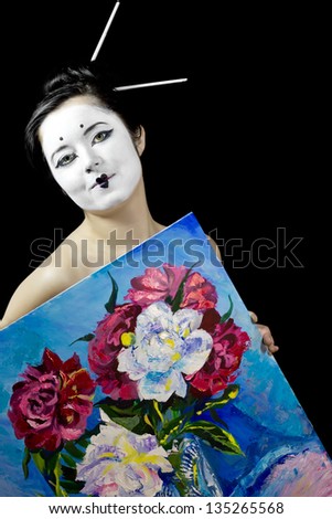 Geisha with white face keeps a oil picture isolated on black