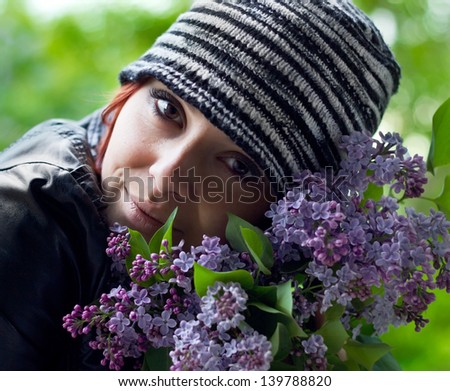 Closeup woman face in hat with lilac bouquet