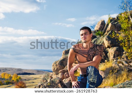 Portrait of man with ethno tattoo outdoors