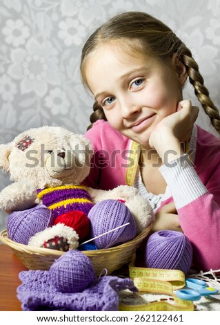 Portrait of little girl with knitting basket and bear