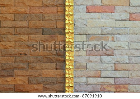 Brick wall mixed pattern separate by vertical line with the flower golden coated style .