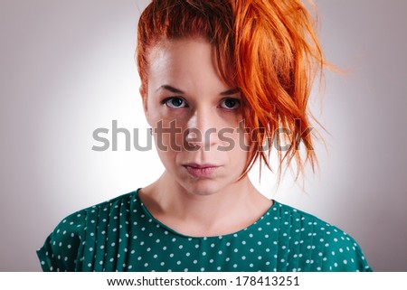 Portrait of a beautiful redhead woman with a serious expression