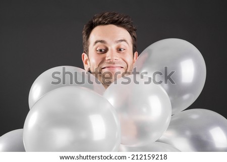Man looking down over white balloons
