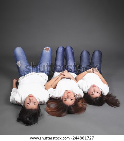 Three sisters lying on the floor in jeans