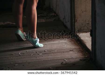 Human legs in shoes standing in the ruined dirty room