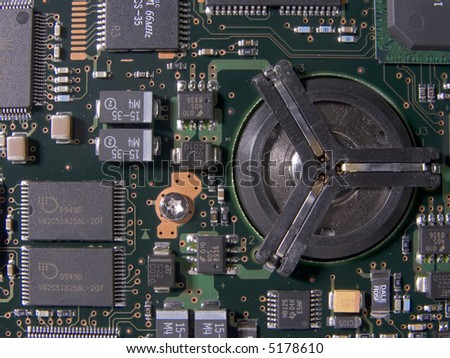 Surface mount components on a green circuit board surrounding a hard drive spindle mount