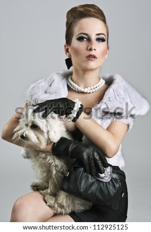 Posh, rich lady is holding a sweet maltese dog