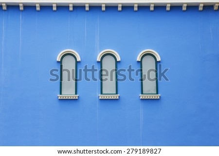 Beautiful arched window on blue wall background wallpaper design