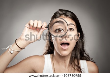 woman looking at camera through magnifying glass